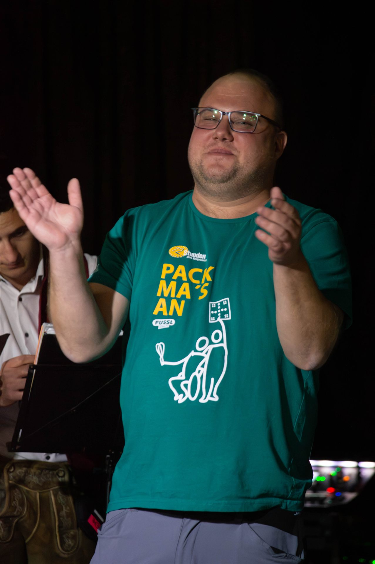 Helfer im Pack-ma's-an-Shirt applaudiert