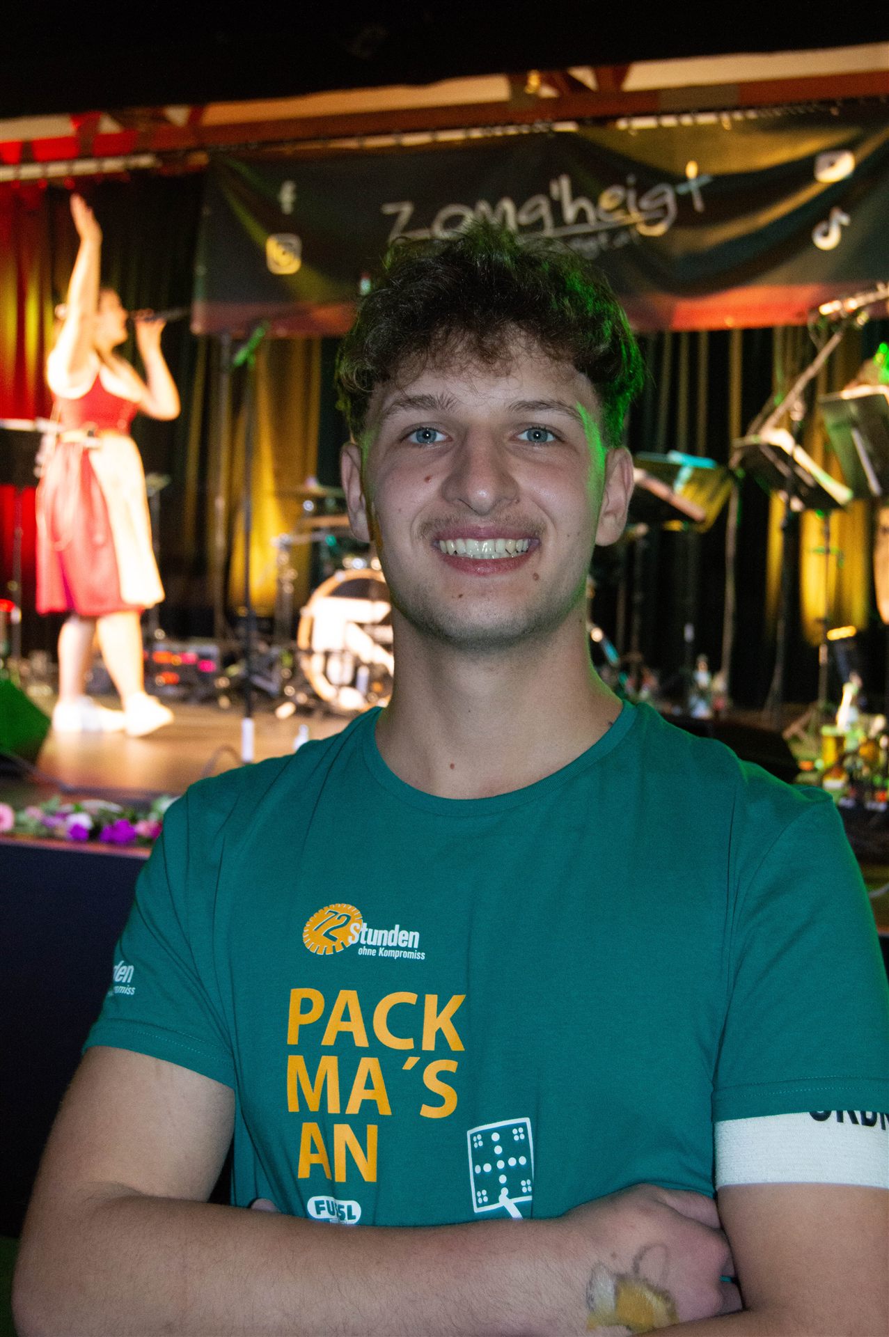 Helfer im Pack-ma's-an-Shirt vor der Bühne