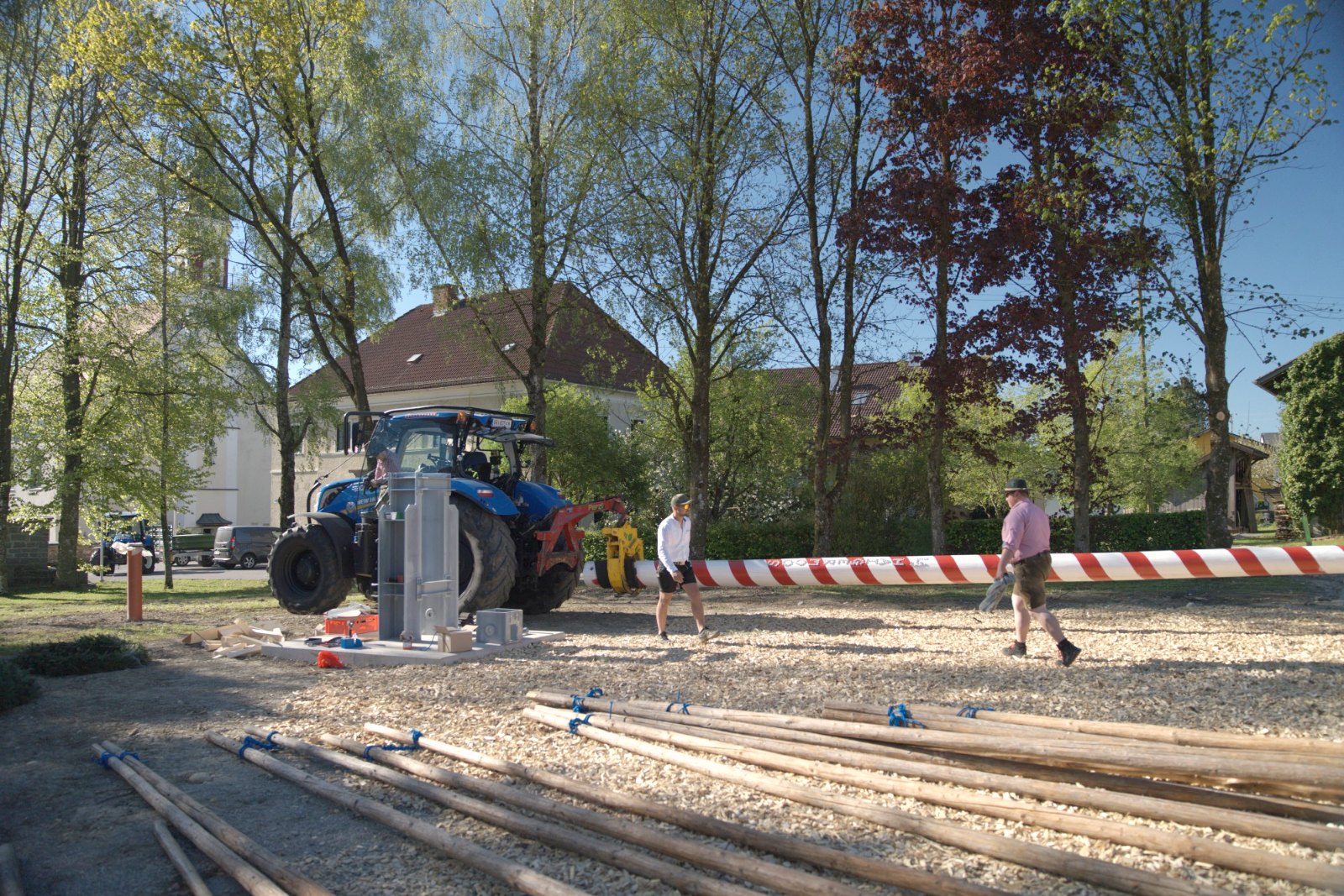 Vorbereitung am Dorfplatz: Traktor, Maibaum und Stangen liegen bereit