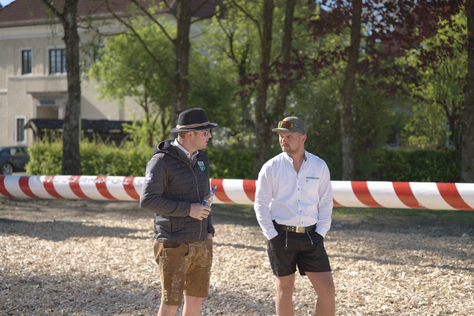Zwei Landjugend-Mitglieder besprechen sich vor dem liegenden Maibaum